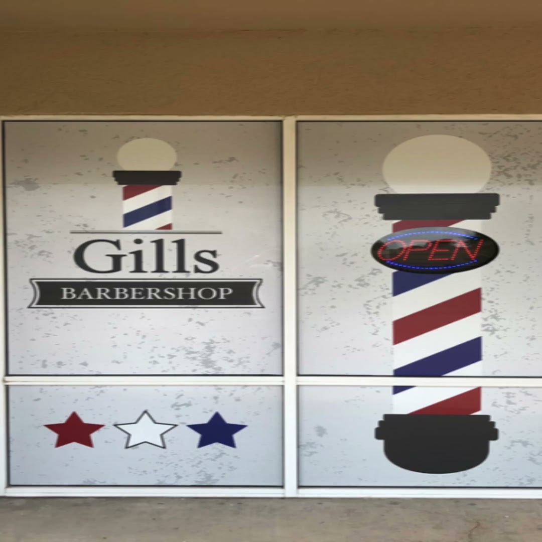Gills Barbershop storefront — window decals with the wordmark, red-white-blue barber pole, OPEN sign, tri-color stars.